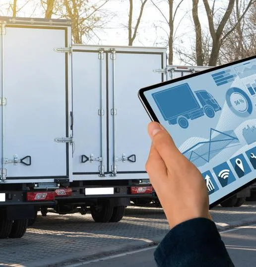 Driver reviewing fleet data on a tablet beside a delivery vehicle